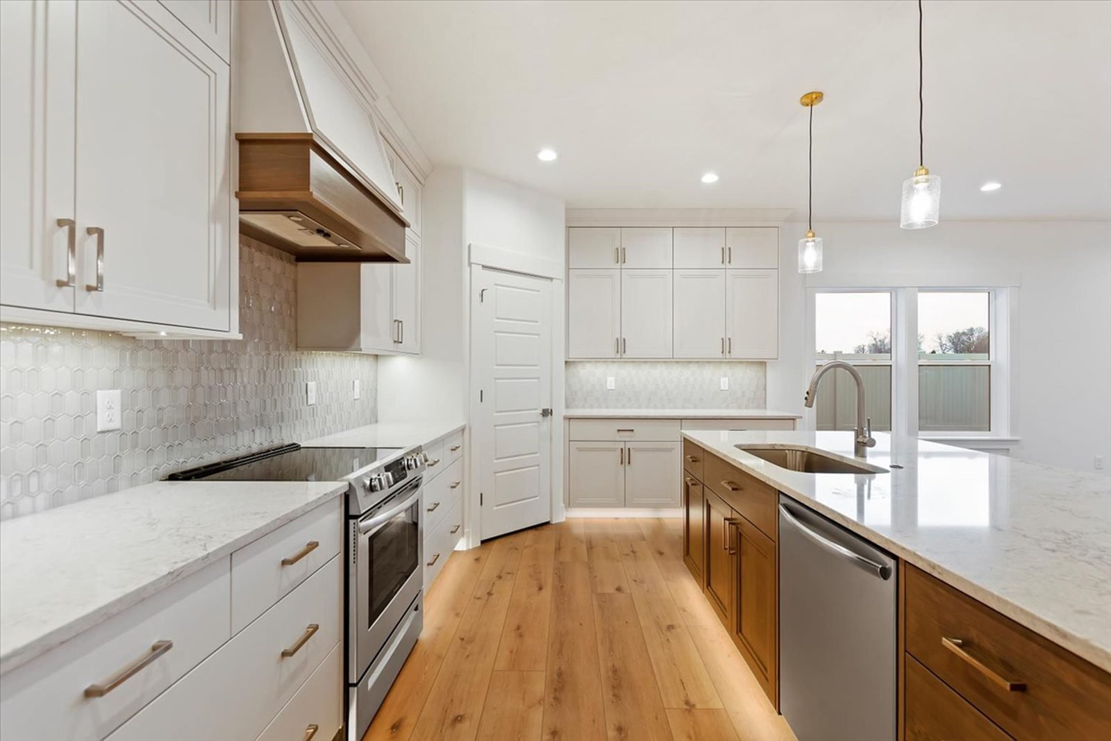 Kitchen with a wood range hood and white cabinetry